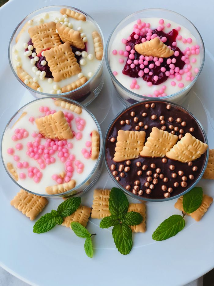 hero-img-01 Homemade dessert cups topped with biscuits, colorful sprinkles, and mint leaves. Perfect for sweet cravings.