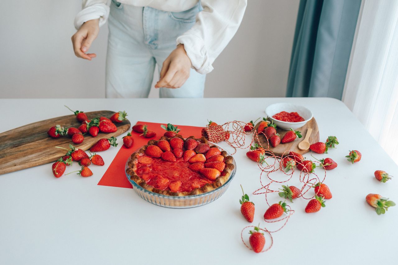 ours-journey Delightful strawberry pie with fresh fruits on a table. A perfect dessert presentation.